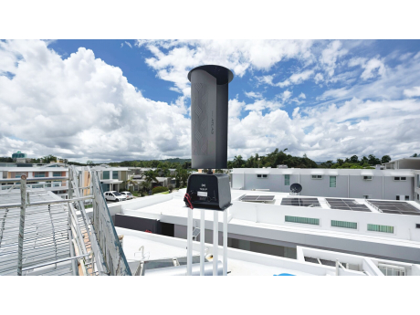 Een Wekraft Atlas-windturbine op een plat dak onder een blauwe hemel