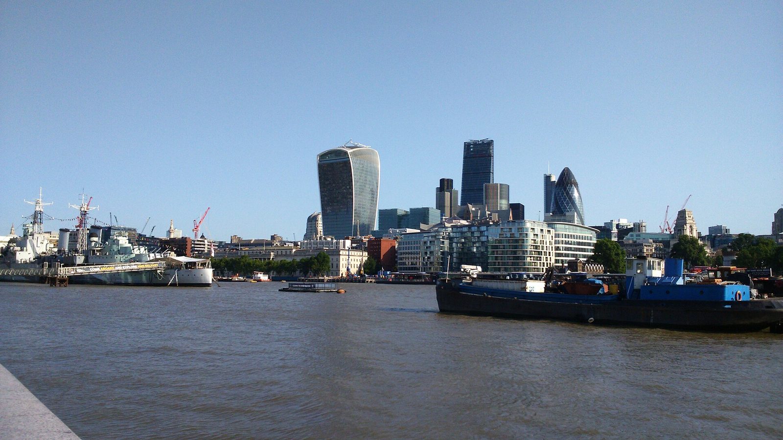 De City of London gezien over de Theems onder een heldere, gebroken hemel