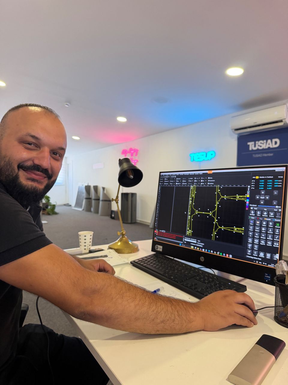 Wekraft technician Okan Gumus at the CNC control screen, cutting paths and pierce points visible on the monitor