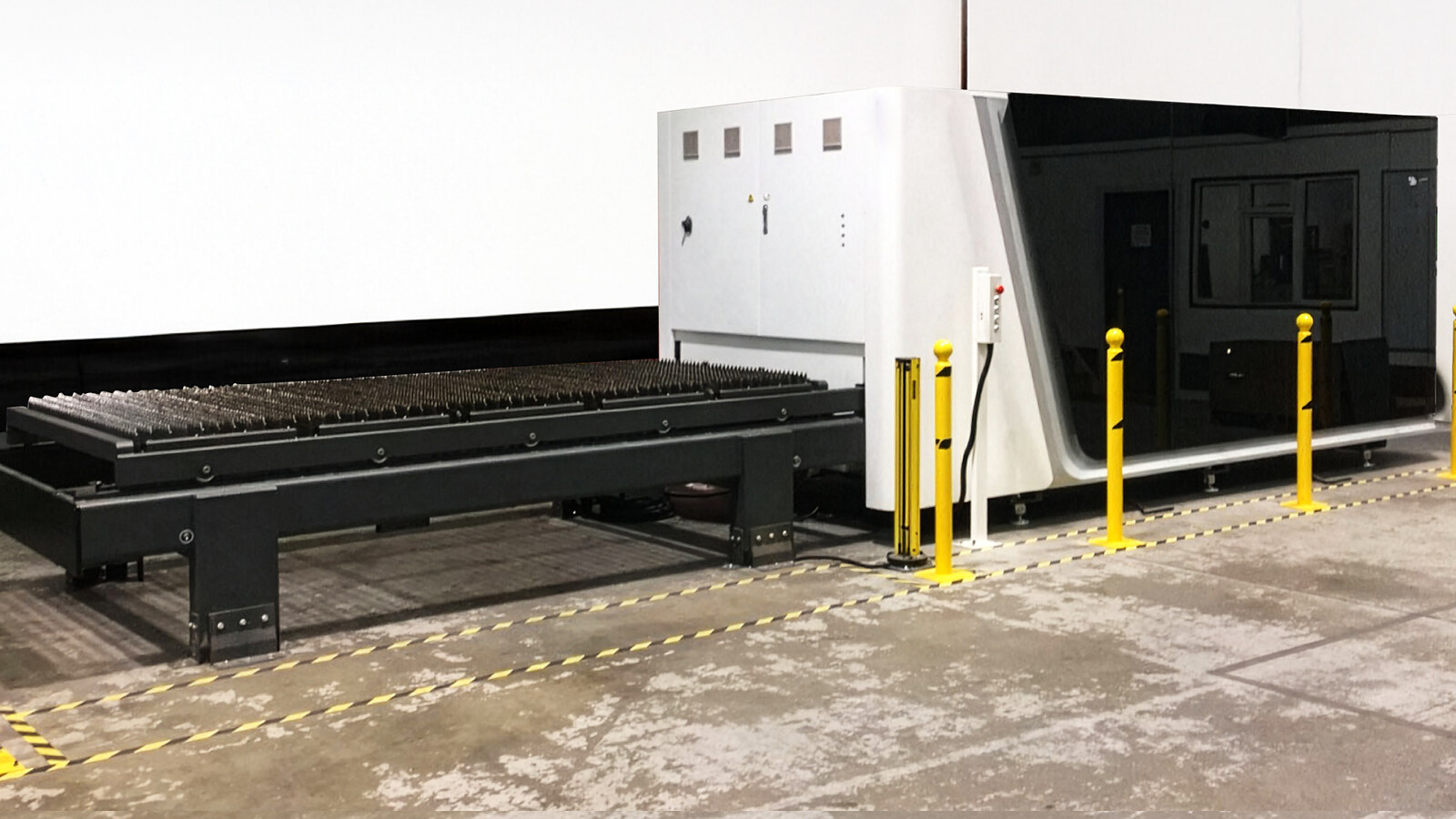 Een nieuw opgestelde BODOR-lasersnijder op een fabrieksvloer van Wekraft, achter gele aanrijdbeveiliging en waarschuwingsmarkering